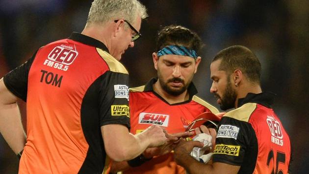 Sunrisers Hyderabad (SRH) batsman Yuvraj Singh(C) shows his injured finger to Shikhar Dhawan (R) and coach Tom Moody during their Indian Premier League (IPL) match against Mumbai Indians at the Rajiv Gandhi International Cricket Stadium in Hyderabad on Monday.(AFP)