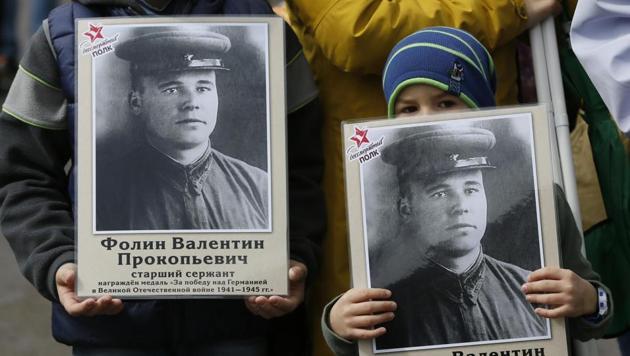 Children hold pictures of World War II soldiers as they take part in the Immortal Regiment march in Russia. (ilya Naymushin/REUTERS) Children hold pictures of World War II soldiers as they take part in the Immortal Regiment march in Russia. (ilya Naymushin/REUTERS)