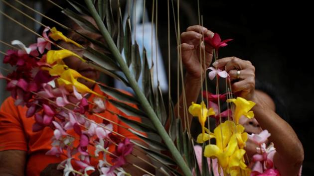 A woman prepares a palm leaf with flowers before a procession. (Jose Cabezas / Reuters) A woman prepares a palm leaf with flowers before a procession. (Jose Cabezas / Reuters)