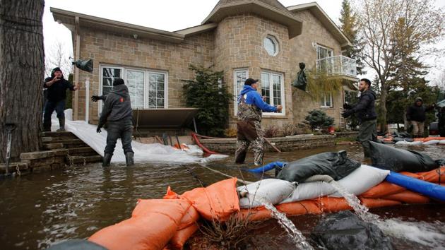 Men throw sandbags outside a home in a flooded residential area in Gatineau. Most of the streets here are flooded, forcing locals to travel by canoe or other small boat. (Chris Wattie/REUTERS)
