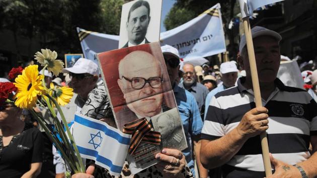 Russian-Israeli World War II veterans and their relatives hold pictures of late comrades during a march in the Jerusalem to mark Victory Day. (Menahem Kahana/afp) Russian-Israeli World War II veterans and their relatives hold pictures of late comrades during a march in the Jerusalem to mark Victory Day. (Menahem Kahana/afp)