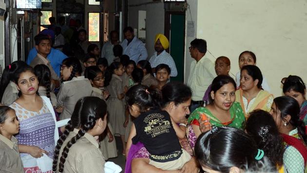 Parents along with their wards waiting outside the DEO’s office in Ludhiana on Monday.(JS Grewal/HT Photo)