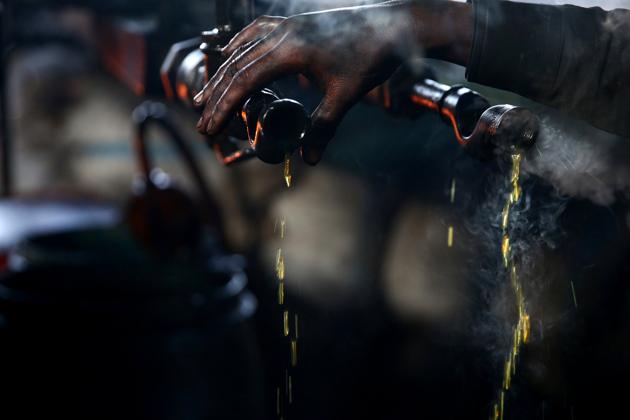 A man checks the heat of a pipe pouring with fuel, inside a workshop. The liquid is refined into gasoline, diesel and benzene fuels, and the gasses obtained are sold for domestic and commercial use in place of natural gas. (Bassam Khabieh / Reuters) A man checks the heat of a pipe pouring with fuel, inside a workshop. The liquid is refined into gasoline, diesel and benzene fuels, and the gasses obtained are sold for domestic and commercial use in place of natural gas. (Bassam Khabieh / Reuters)