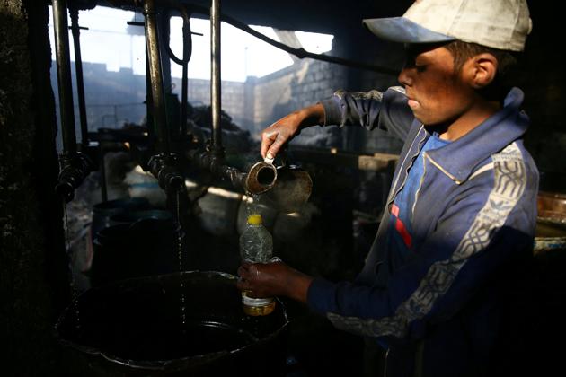 A young man inspects fuel inside a workshop . A litre of benzene fuel sells for 2,200 Syrian pound ($4.70), and a litre of diesel for 2,000 Syrian pounds. (Bassam Khabieh / Reuters) A young man inspects fuel inside a workshop . A litre of benzene fuel sells for 2,200 Syrian pound ($4.70), and a litre of diesel for 2,000 Syrian pounds. (Bassam Khabieh / Reuters)