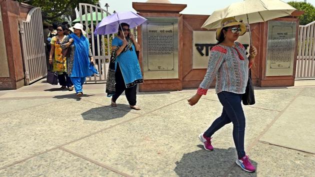 People cover themselves using umbrellas as scorching heat made a comeback over NCR, with mercury touching the 43 degree mark  yesterday.  (Sonu Mehta/HT PHOTO) 