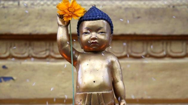 A devotee (unseen) sprinkles rice grains as part of the rituals on the idol of Buddha, at Swayambhu in Kathmandu. Devotees visit temples, light candles and incense sticks, pray and offer sweets and fruits before the statue of Lord Buddha. (Navesh Chitrakar/REUTERS)