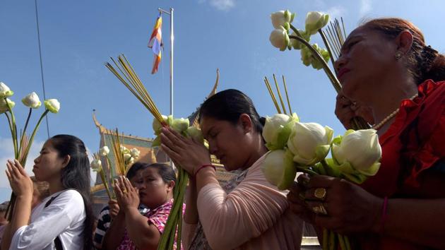 Cambodian women pray in front of a shrine out side the Royal Palace in Phnom Penh. Sermons on the life and teachings of Buddha are held and attended by followers in larger numbers. (Tang Chhin Sothy/AFP)