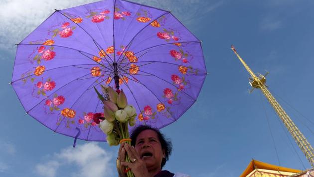 A Cambodian woman prays in front of a shrine out side the Royal Palace in Phnom Penh. People usually dress in white and distribute kheer as according to Buddhist lore, on this day a woman named Sujata had offered Buddha a bowl of milk porridge. (Tang Chhin Sothy/AFP)