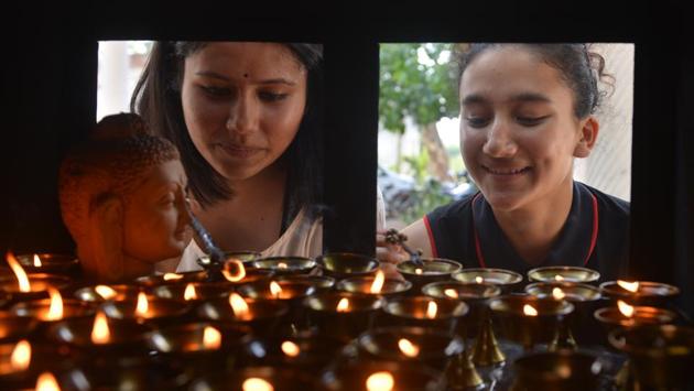 Devotees visit temples, light candles and incense sticks, pray and offer sweets and fruits before the statue of Lord Buddha. (Karun Sharma / HT Photo) 
