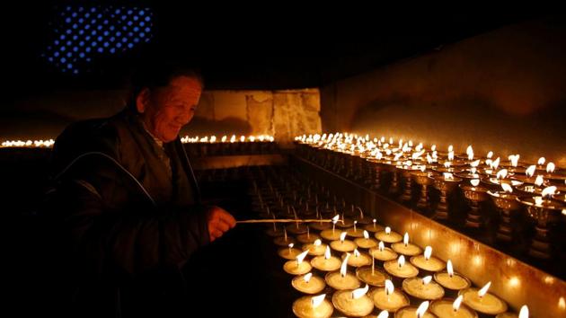 A devotee lights butter lamps on the birth anniversary of Buddha. (Navesh Chitrakar/REUTERS)