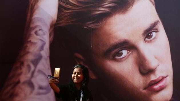A girl takes a selfie in front of a hoarding outside the venue of Canadian singer Justin Bieber concert in Mumbai, India. (REUTERS) A girl takes a selfie in front of a hoarding outside the venue of Canadian singer Justin Bieber concert in Mumbai, India. (REUTERS)