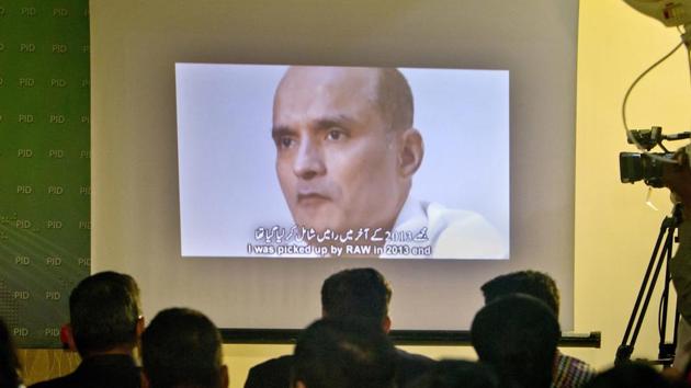 In file photo, journalists look at an image of former Indian naval officer Kulbhushan Jadhav, who was arrested in March 2016. (AP File Photo) In file photo, journalists look at an image of former Indian naval officer Kulbhushan Jadhav, who was arrested in March 2016. (AP File Photo)