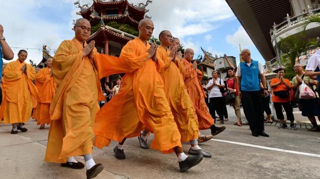 Monks leading devotees pray outside the Kong Meng San Phor Kark See Monastery (KMSPKS) during a ritual on the eve of Vesak day in Singapore. Vesak Day commemorates the birth, enlightenment of Buddha, and is celebrated by Buddhists in Asia. (Roslan Rahman/AFP)