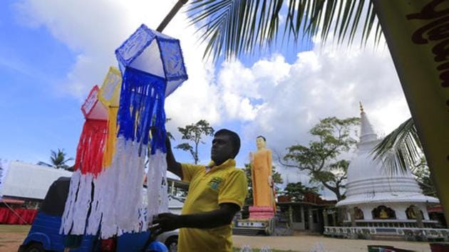 A Sri Lankan man hangs decorative lanterns outside a Buddhist Temple on the eve of Vesak, or Buddha Purnima, festival in Colombo. (Eranga Jayawardena/AP)