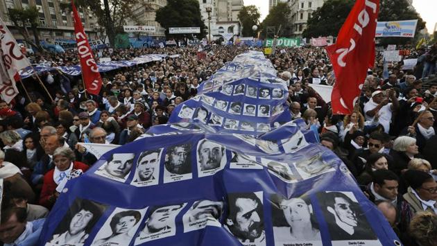 People hold a banner with photos of persons killed during Argentina's 1976-1983 dictatorship. Activists had warned that the ruling could set a precedent leading to the early release of other abusers. (Victor R. Caivano/AP)