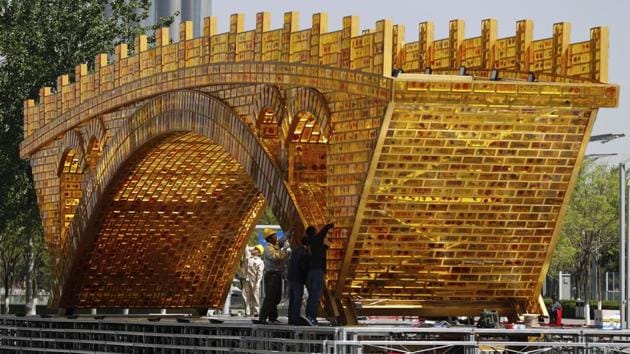 Workers install wires on a 'Golden Bridge of Silk Road' structure on a platform outside the National Convention Centre, the venue for the Belt and Road Forum for International Cooperation, in Beijing, April 18, 2017. Leaders of 28 countries are set to attend the Chinese summit showcasing President Xi Jinping's signature foreign policy plan.(AP)