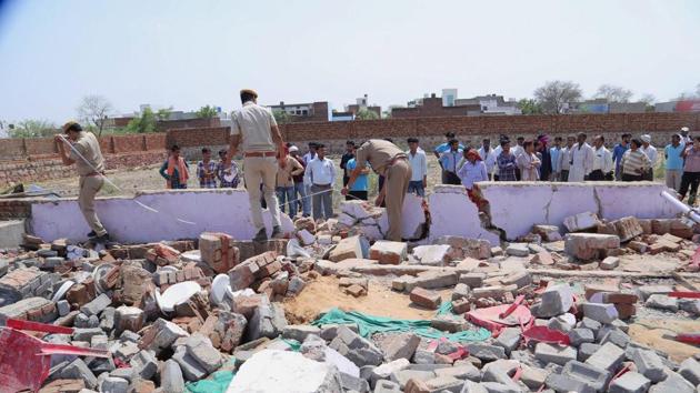 Police officials inspect the collapsed wall at the marriage hall in Bharatpur on Thursday. (PTI Photo) Police officials inspect the collapsed wall at the marriage hall in Bharatpur on Thursday. (PTI Photo)