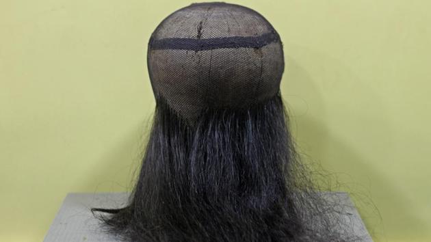 Two or three strands of hair at a time are knotted into the net. The knotting techniques used at the base and the crown are different. (Satyabrata Tripathy / HT Photo)