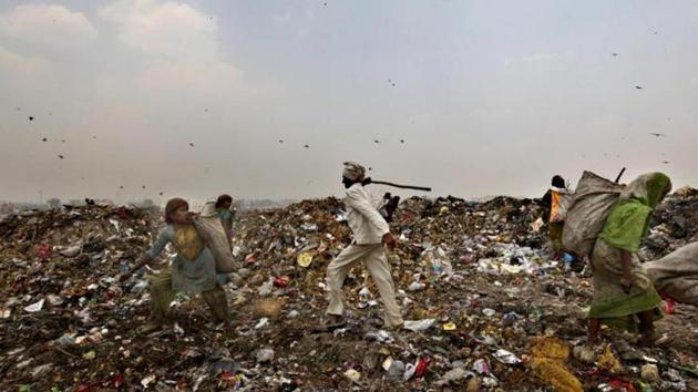 An civic body worker chases away ragpickers with a stick at the Ghazipur landfill site in east Delhi.(Raj K Raj/HT File Photo) An civic body worker chases away ragpickers with a stick at the Ghazipur landfill site in east Delhi.(Raj K Raj/HT File Photo)