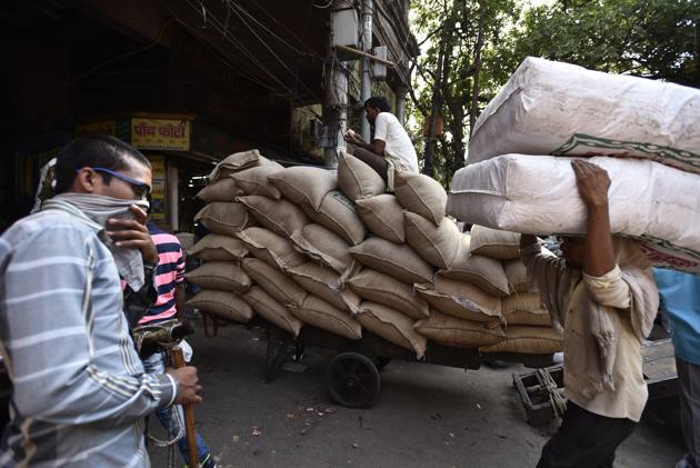 A labourer hauls sacks of spices in Khari Baoli spice market, in New Delhi. Many of the men working here are migrants from neighbouring states of Bihar and Uttar Pradesh. (Burhaan Kinu/HT PHOTO)