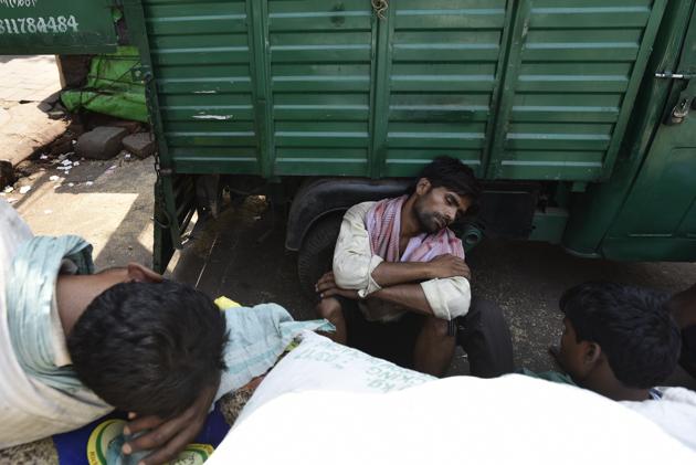Catching a short-lived break to sleep in between truckloads of sacks waiting to be offloaded in godowns. (Burhaan Kinu/HT PHOTO)