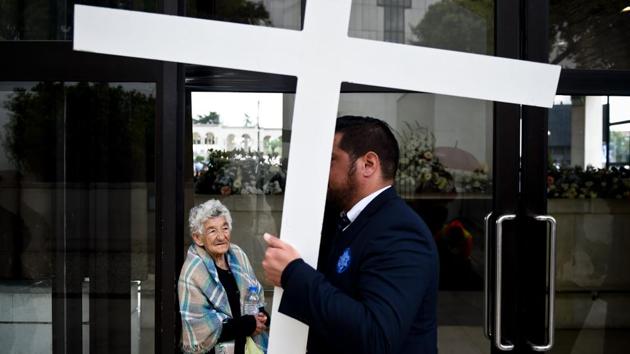 A woman outside the chapel "Capelinha das Aparicoes" looks at a man carrying a cross at Fatima. Border controls, meanwhile, have been reinstated in the EU country through the weekend. (Patricia De Melo Moreira/AFP)