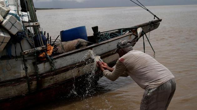 A farm worker washes his pig in a boat. In Amapá, the Brazilian state with the highest rate of unemployment last year, many residents are eager for potential benefits from the oil industry. (Ricardo Moraes/REUTERS)