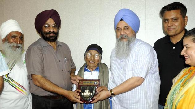 Dean, academic affairs, Gurnam Singh honouring athlete Mann Kaur at Punjabi University in Patiala on Thursday.(Bharat Bhushan/HT Photo)