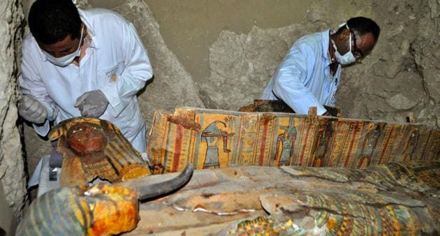 Members of an Egyptian archaeological team work on a wooden coffin discovered in a 3,500-year-old tomb in the Draa Abul Nagaa necropolis, near the southern Egyptian city of Luxor, on April 18.(AFP File Photo)