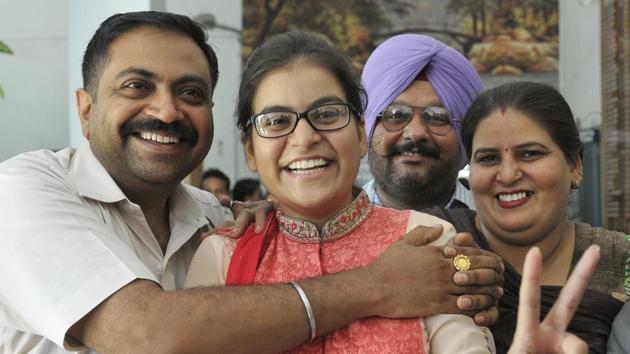 Amisha Arora, the state topper, with her family in Ludhiana. (Gurminder Singh /HT)