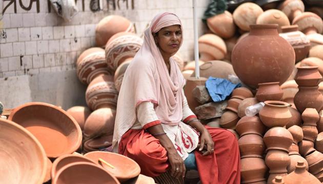 Forty-year-old Tarawati sells earthenware made by her husband at New Friends Colony.On a day that cherishes and honours motherhood, let us spare a thought for the women who have striven against all odds to protect and nurture their families. This photo feature takes us into the lives of some of these courageous mothers who have made a life of dignity for themselves and their children on the unforgiving streets of Delhi. (Burhaan Kinu/HT PHOTO)
