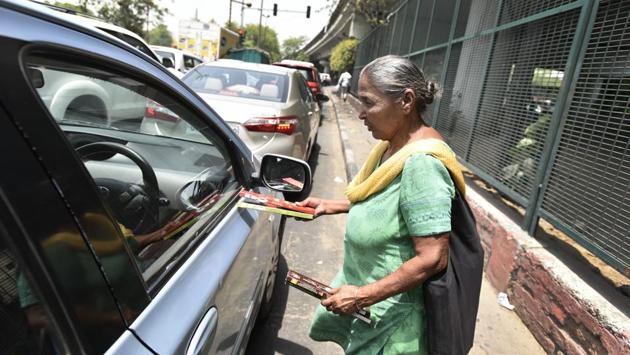 Harjit Kaur, 85, has been selling incense sticks at the traffic signal near Chiragh Delhi flyover for over two decades. A mother of four, her children have all passed away. One of her sons, who sold incense sticks along with her, died after being hit by a truck - a danger she too deals with every day. (Burhaan Kinu/HT PHOTO)
