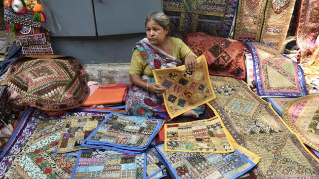 Prem Rani, 60, has been hawking embroidered cushion covers at the bustling Janpath market for the past thirty years. A mother of two, both of whom are now married and have children of their own. (Burhaan Kinu/HT PHOTO)