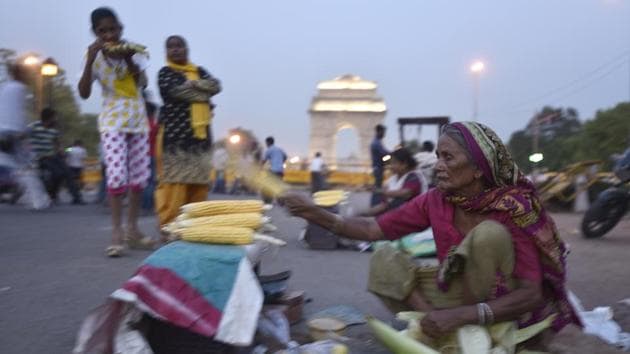 Raj Rani migrated from Bihar, some thirty years ago and since then has been selling roasted corn at India Gate. On most days, she sets up her tiny stall at 7pm and is there till 11pm at night. She supplements her earnings with mineral water bottles and packaged food items. (Burhaan Kinu/HT PHOTO)