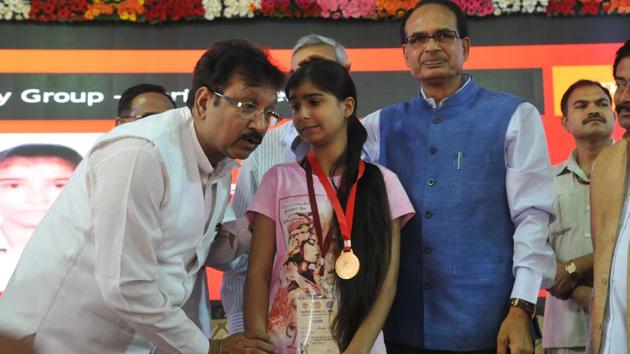Madhya Pradesh School education minister Kunwar Vijay Shah with a topper, in the presence of chief minister Shivraj Singh Chouhan, during felicitation function of meritorious students of the MP state board examinations in Bhopal on 12. (Mujeeb Faruqui/HT Photo) Madhya Pradesh School education minister Kunwar Vijay Shah with a topper, in the presence of chief minister Shivraj Singh Chouhan, during felicitation function of meritorious students of the MP state board examinations in Bhopal on 12. (Mujeeb Faruqui/HT Photo)