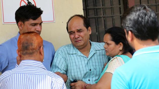 Family members consoling victim Reena Devi’s (above) husband Sandeep Kumar in Panchkula on Friday.(Sant Arora/HT Photo)