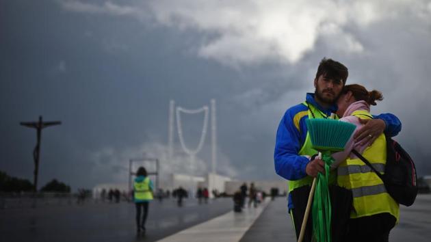 A couple hug each other upon their arrival to Fatima Sanctuary in central Portugal. Tens of thousands of Catholic faithful await the high-security arrival of Pope Francis in Fatima on Friday as the Portuguese holy site marks 100 years since the Virgin Mary reportedly appeared to child shepherds. (Patricia De Melo Moreira/AFP)