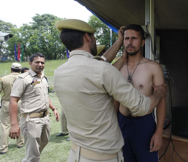 Police officers measure the height of a Kashmiri youth during the recruitment rally. (Waseem Andrabi / HT Photo) Police officers measure the height of a Kashmiri youth during the recruitment rally. (Waseem Andrabi / HT Photo)