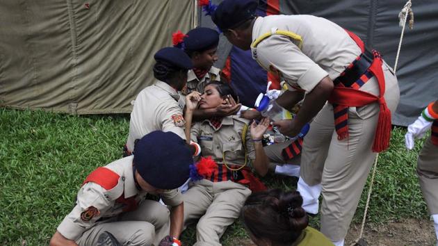 Indian police personnel assist a colleague after she fainted during a passing out ceremony at a police training academy in Agartala. 132 women police cadets passed out in the ceremony in the north-eastern state of Tripura. (Arindam DEY / AFP)