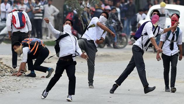 Masked Kashmiri students throw stones during clashes with police in Srinagar on Thursday.(AFP)