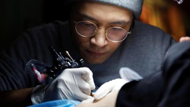 Shi Hailei, 32, a tattoo artist who gives free tattoos to mothers that want to cover up their caesarean delivery (C-section) scars, works in Samurai Tattoo studio . (Aly Song / Reuters) Shi Hailei, 32, a tattoo artist who gives free tattoos to mothers that want to cover up their caesarean delivery (C-section) scars, works in Samurai Tattoo studio . (Aly Song / Reuters)