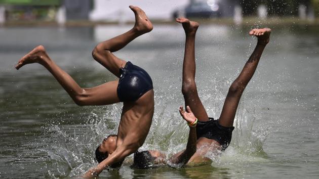 Children take a dip in the pond at India Gate in New Delhi on Sunday. (Ravi Choudhary/HT PHOTO) Children take a dip in the pond at India Gate in New Delhi on Sunday. (Ravi Choudhary/HT PHOTO)