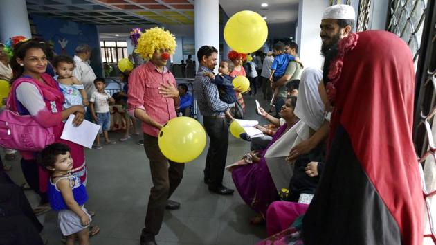 The clowns form a chain as they enter the hospital singing and dancing into the patient wards. They then perform plays, use mimes and even engage the adults in a game with balloons. (Raj K Raj/HT Photo)