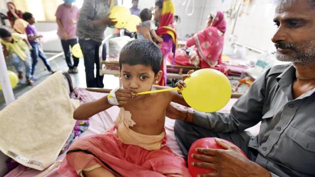 A child admitted to a ward inflates a balloon gifted to him by the volunteers. (Raj K Raj/HT Photo)