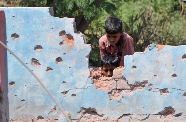 Children at a house damaged by mortar shells fired from the Pakistan side of the border, at Jhanghar village, in Nowshera.(Nitin Kanotra /HT Photo)