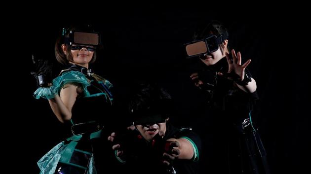 Piyohina, Junpei Sasaki, Rimiko Sakihama (L-R), members of HADO team ‘Slamdiva’, pose for a photograph wearing head-mount displays and armband sensors in Tokyo, Japan. (REUTERS)