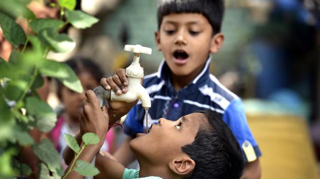 Children quench their thirst by drinking tap water in New Delhi. As the temperature in Delhi rises, physicians are advising people to stay indoors and drink plenty of fluids to keep themselves dehydrated. (Raj K Raj/HT PHOTO)