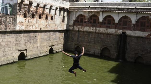 A man dives into the waters of a stepwell at Nizamuddin Dargah on a hot summer day in New Delhi. (Burhaan Kinu/HT PHOTO)