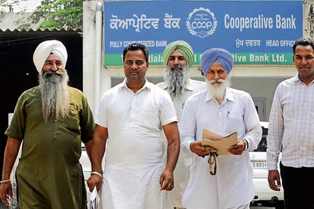 Farmers coming out of the Central Cooperative Bank in Patiala. (HT File Photo) Farmers coming out of the Central Cooperative Bank in Patiala. (HT File Photo)