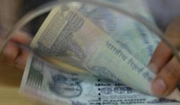 A customer counts Rs 100 notes after withdrawing money at a bank on November 24, 2016, in the wake of the demonetisation of old Rs 500 and Rs 1000 in Mumbai. (AFP) A customer counts Rs 100 notes after withdrawing money at a bank on November 24, 2016, in the wake of the demonetisation of old Rs 500 and Rs 1000 in Mumbai. (AFP)